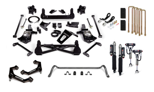 An assortment of automotive suspension parts, including shocks, control arms, brackets, bolts, U-bolts, and sway bars for a 2011-2019 Silverado/Sierra 2500/3500 with the Cognito Motorsports' 7-Inch Premier Lift Kit featuring Elka 2.5 Shocks. The parts are primarily black with some metallic and copper elements laid out on a white background.