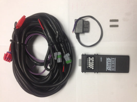 The AMP Research 2009-2014 Ford F150 PowerStep Plug N Play Conversion Kit includes a coiled black cable with connectors, a circular black component with attached wiring, two small cylindrical metal parts, and a black rectangular device branded "AMP Research POWERSTEP," all neatly arranged on a white background.