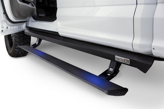 A close-up of a white vehicle featuring the AMP Research 21-23 Ford Bronco 4 Door XL PowerStep, an automatic electric-powered running board ideal for lifted trucks. The black board is illuminated with blue lighting and positioned under the open door.