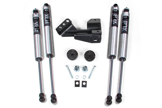 The image displays a set of BDS performance suspension components designed for 2017-2019 Ford F250 and F350 Super Duty, including four Fox shock absorbers, a black mounting bracket, two black round plates, bolts, nuts, and washers neatly arranged on a white surface. The product is the BDS 2 Inch Leveling Kit with Coil Spacers for 4WD models.