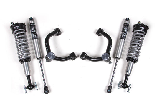 The 2 Inch Leveling Kit by BDS, featuring FOX 2.0 Coil-Over shocks, designed for the 2021-2023 Ford F150 4WD, is showcased. The kit includes two coil-over shocks with springs, two additional shocks, and two control arms. All components are metallic with black and silver finishes, neatly arranged on a white background.