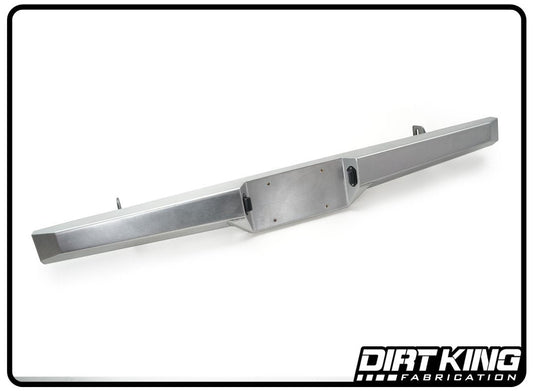 An off-road vehicle bumper from Dirt King. The metallic and sleek 99-06 GM 1500 Plate Rear Bumper by DIRT KING is designed for durability, heavy-duty use, and increased ground clearance. Displayed on a plain white background, the lightweight design showcases the DIRT KING logo in the bottom right corner.