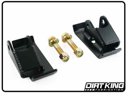 A set of 99-23 GM 1500 Leaf Over Shock Mounts, featuring black metal brackets with two gold-colored bolts and nuts, is displayed against a white background. Sturdy and likely components for mechanical assembly or a prefabbed bedcage, the brackets bear the "DIRT KING" logo in the bottom right corner.