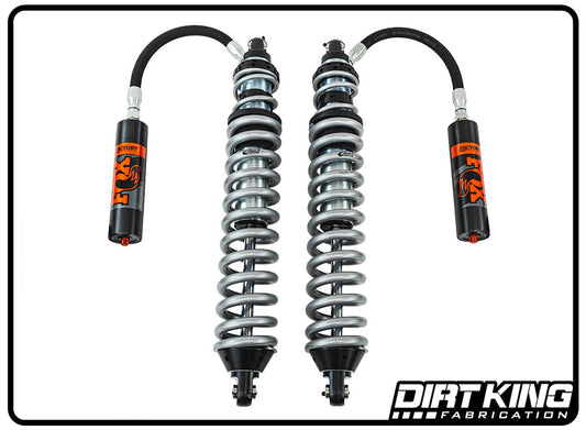 The image showcases a pair of Dirt King 07-18 GM 1500 Long Travel Spec Fox Coilovers from DIRT KING SHOCKS, perfect for off-road performance. Each coilover features a silver coil spring around a blue piston with black and orange reservoir tanks attached by hoses. The DIRT KING SHOCKS logo is at the bottom right.
